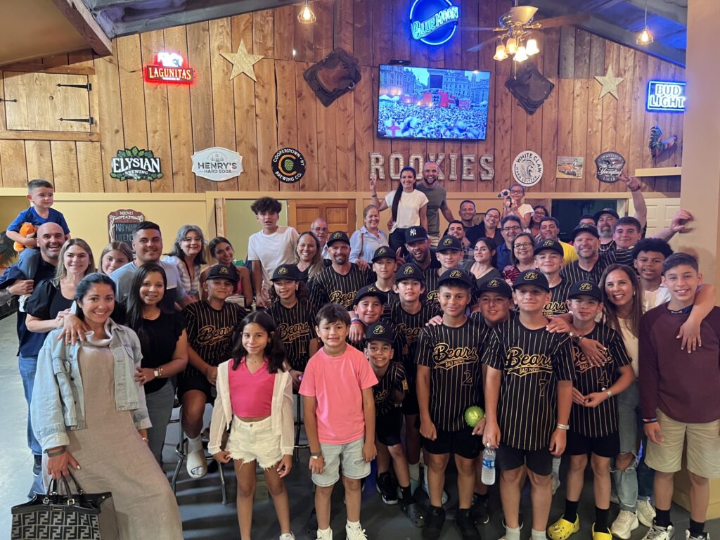 Young players in team uniforms with family members gathered inside the restaurant