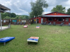Cornhole boards set up on the lawn in front of a red building